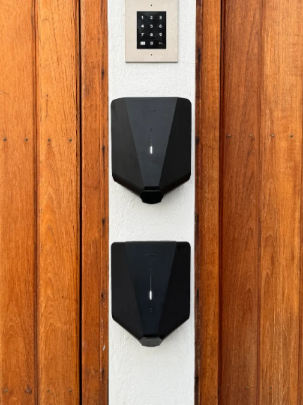 Dubbla Easee laddboxar installerade i Solna – laddstation för två bilar på träfasad.