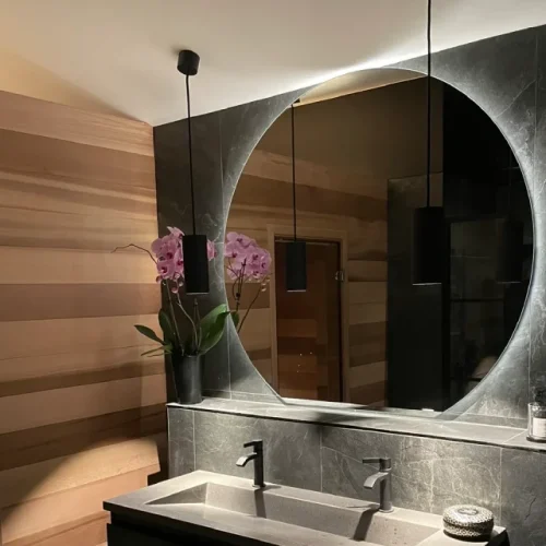 renovering-taby-badrum-modern-belysning Exklusiv badrumsrenovering i Täby med infälld spegelbelysning och moderna svarta detaljer – installerat av certifierad elektriker.